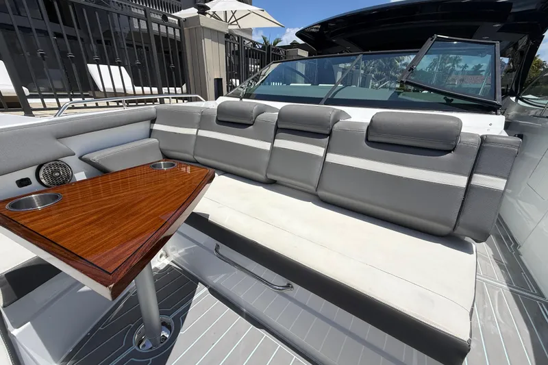 Slide: The Image of Luxurious seating area on 2021 Cruisers Yachts 38 GLS OB with wooden table and cup holders. - 12