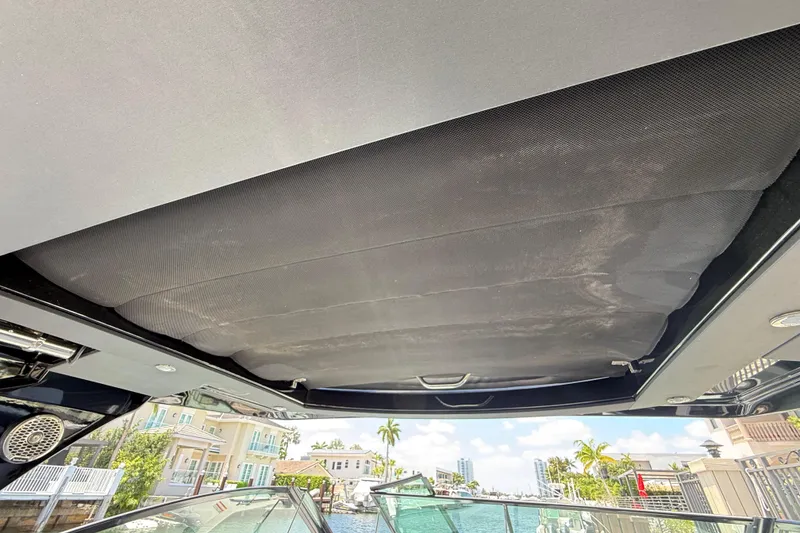 Slide: The Image of 2021 Cruisers Yachts 38 GLS OB with retractable sunroof, docked near waterfront homes. - 21