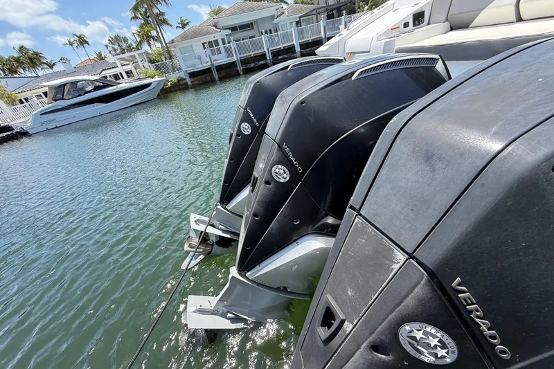 Slide: The Image of Triple outboard engines on a 2021 Cruisers Yachts 38 GLS OB, docked near waterfront homes. - 33