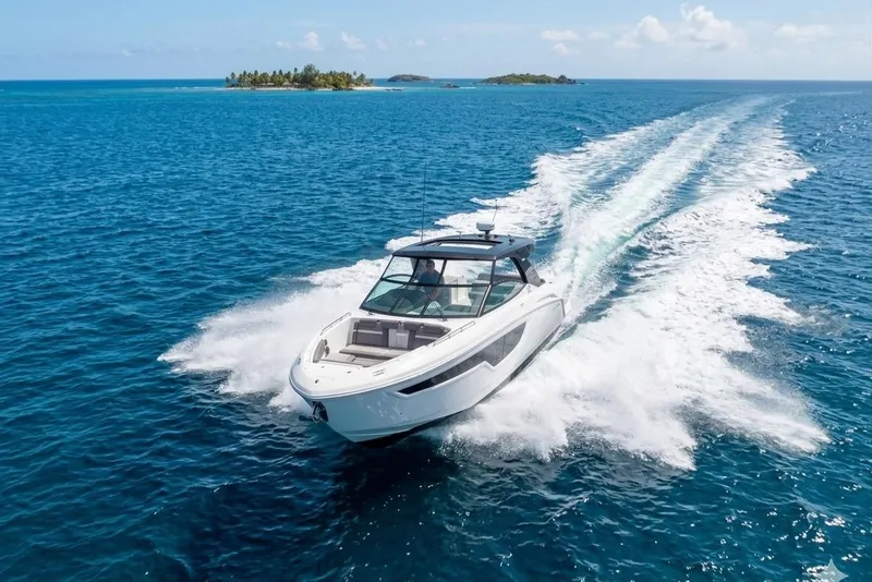 Slide: The Image of 2021 Cruisers Yachts 38 GLS OB speeding on clear blue ocean near tropical island. - 4