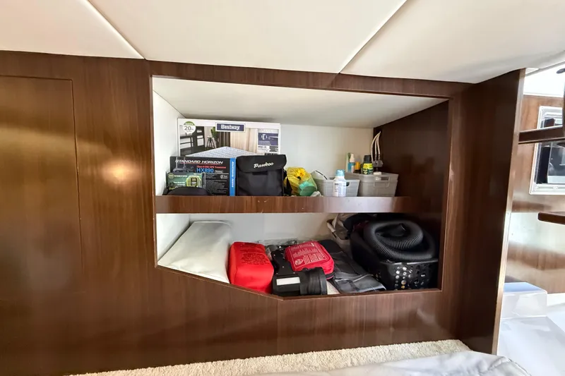 Slide: The Image of Storage shelves on 2021 Cruisers Yachts 38 GLS OB, filled with various boating supplies. - 51