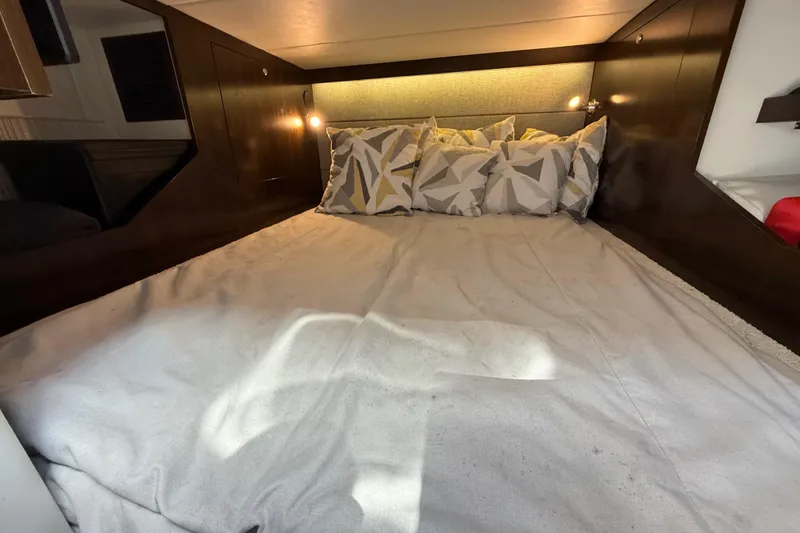 Slide: The Image of Cozy cabin bed in 2021 Cruisers Yachts 38 GLS OB with geometric pillows and ambient lighting. - 56