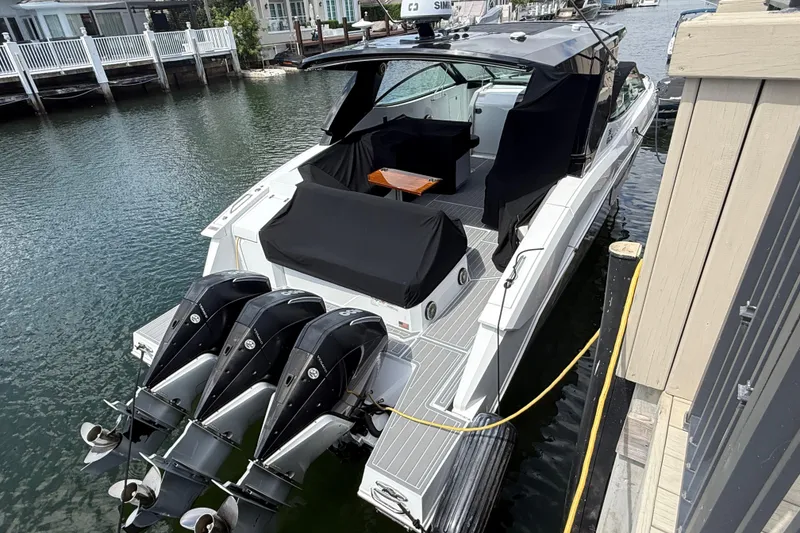 Slide: The Image of 2021 Cruisers Yachts 38 GLS OB docked, featuring triple outboard engines and sleek design. - 9