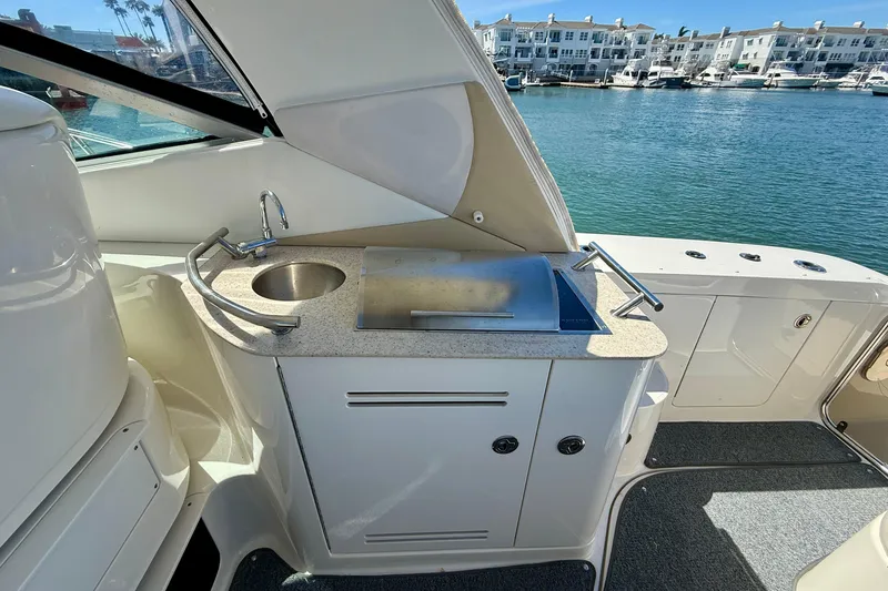Slide: The Image of 2009 Sea Ray Sundancer 350 yacht kitchenette with sink and grill, overlooking marina. - 12
