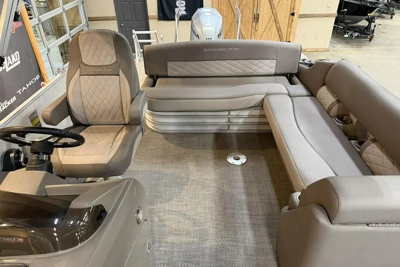 Slide: The Image of 2019 Bennington 22 SSBXP pontoon boat interior with plush seating and steering console. - 5