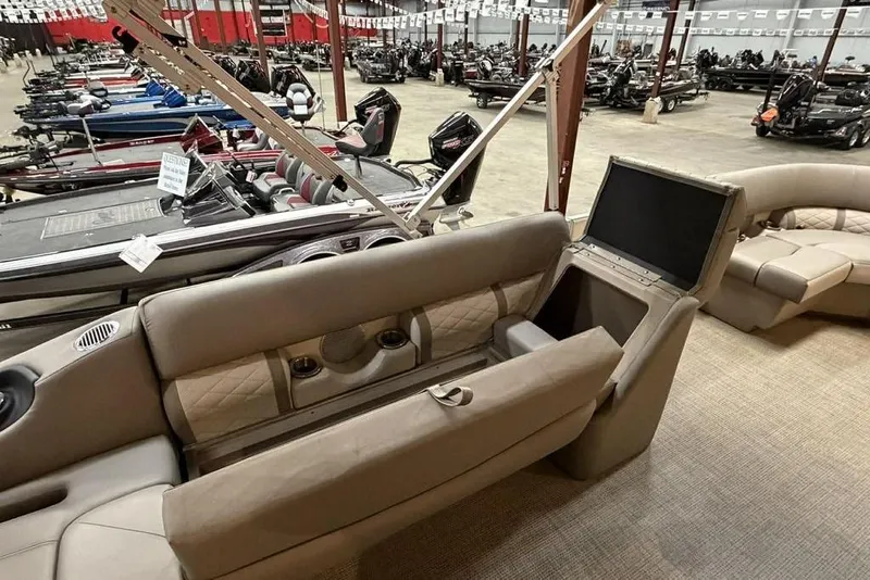 Slide: The Image of 2019 Bennington 22 SSBXP pontoon boat interior with beige seating in a showroom. - 6