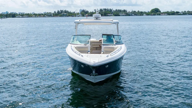 Slide: The Image of 2019 Regal 33 OBX boat on calm water, front view. - 11