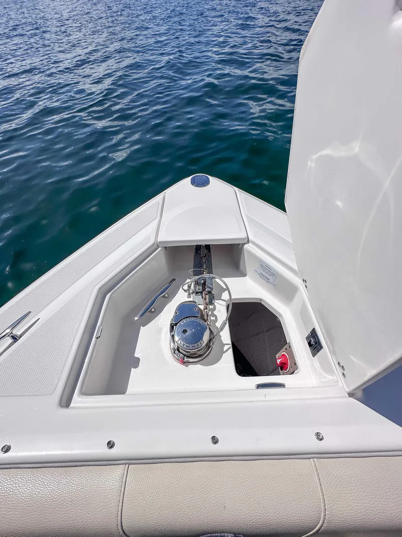 Slide: The Image of 2019 Regal 33 OBX boat anchor compartment with open hatch on calm water. - 24