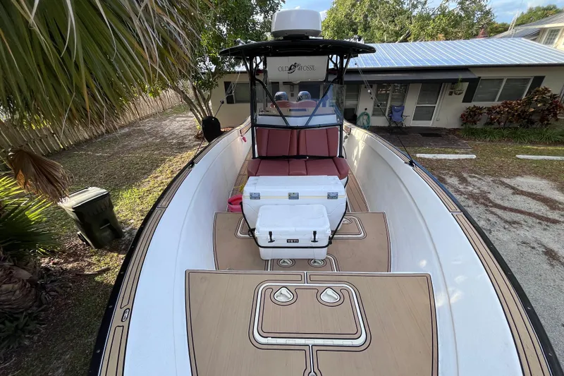 Slide: The Image of 1993 Cape Horn 27 boat with seating and cooler, parked near a house. - 10