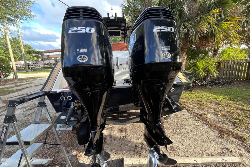 Slide: The Image of Twin 250 horsepower outboard motors on a 1993 Cape Horn 27 boat, parked outdoors. - 13