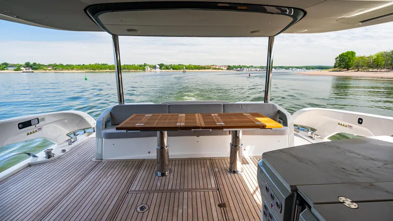 Slide: The Image of Luxury yacht Absolute Navetta 64, 2025 model, featuring elegant deck with scenic water view. - 13