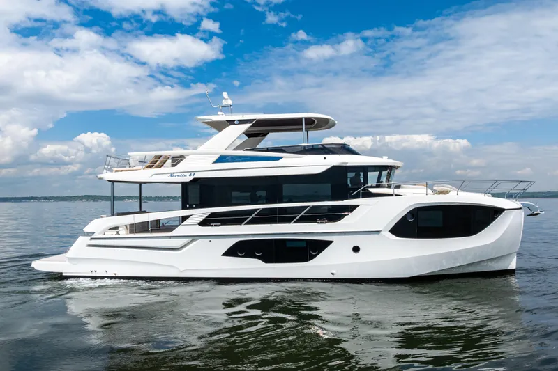 Slide: The Image of 2025 Absolute Navetta 64 yacht cruising on calm waters under a partly cloudy sky. - 3
