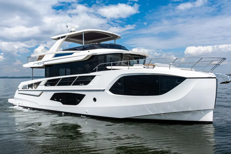 Slide: The Image of 2025 Absolute Navetta 64 yacht cruising on open water under a blue sky. - 4