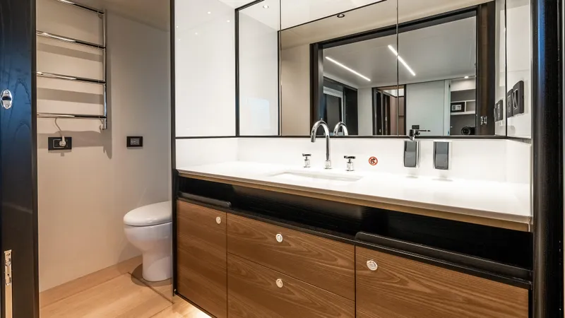 Slide: The Image of Luxurious bathroom in 2025 Absolute Navetta 64 yacht with modern fixtures and wooden cabinetry. - 44