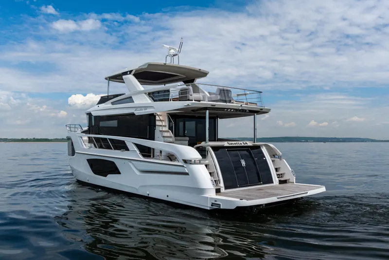 Slide: The Image of 2025 Absolute Navetta 64 yacht cruising on calm waters under a blue sky. - 8