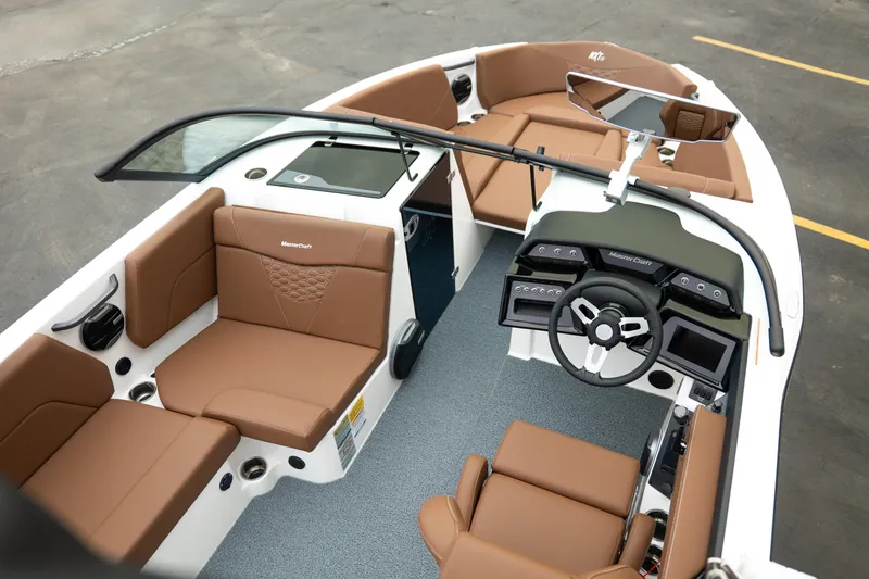 Slide: The Image of 2026 MasterCraft NXT23 boat interior with brown seating and modern dashboard design. - 12