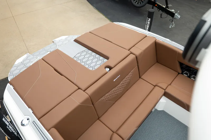 Slide: The Image of 2026 MasterCraft NXT23 boat interior with brown cushioned seating and modern design. - 13