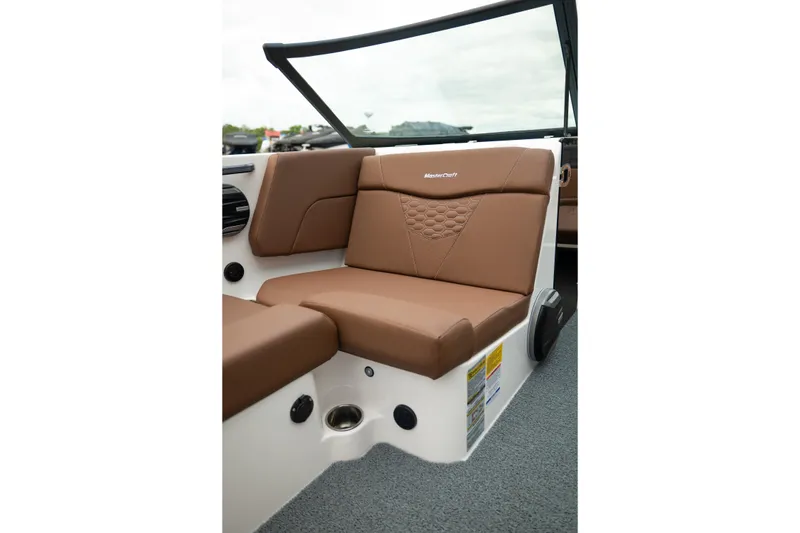 Slide: The Image of 2026 MasterCraft NXT23 boat interior with brown cushioned seating and modern design. - 17