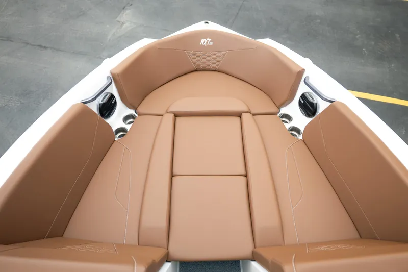 Slide: The Image of 2026 MasterCraft NXT23 boat interior with tan leather seating and cup holders. - 18