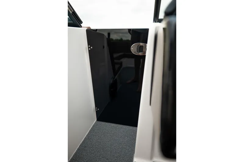 Slide: The Image of 2026 MasterCraft NXT23 boat interior with open door and carpeted floor. - 22