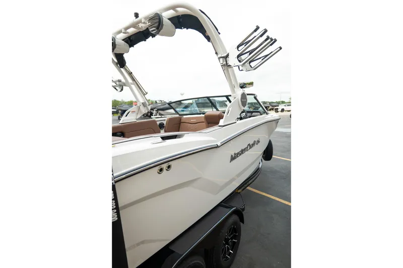 Slide: The Image of 2026 MasterCraft NXT23 boat with sleek design and modern features, parked on a trailer. - 28