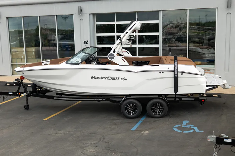 Slide: The Image of 2026 MasterCraft NXT23 boat on trailer, parked outside dealership. - 3