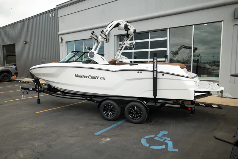 Slide: The Image of 2026 MasterCraft NXT23 boat on trailer outside a building. - 4