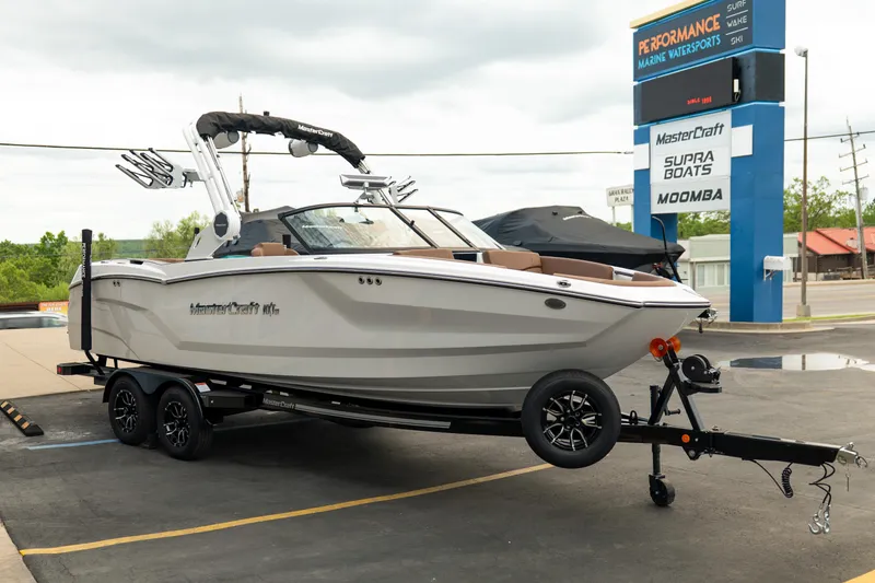 Slide: The Image of 2026 MasterCraft NXT23 boat on trailer at Performance Marine Watersports dealership. - 9