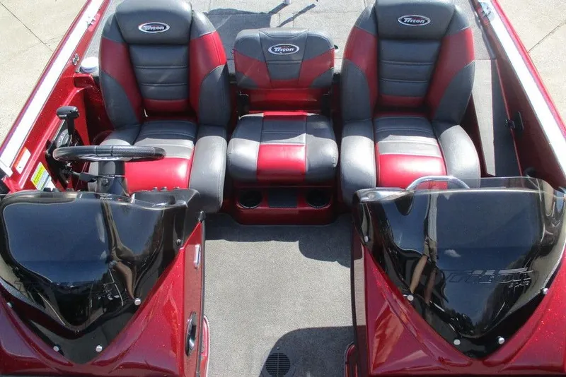 Slide: The Image of 2014 Triton 18XS SC boat interior with red and black seating, dual consoles, and steering wheel. - 6