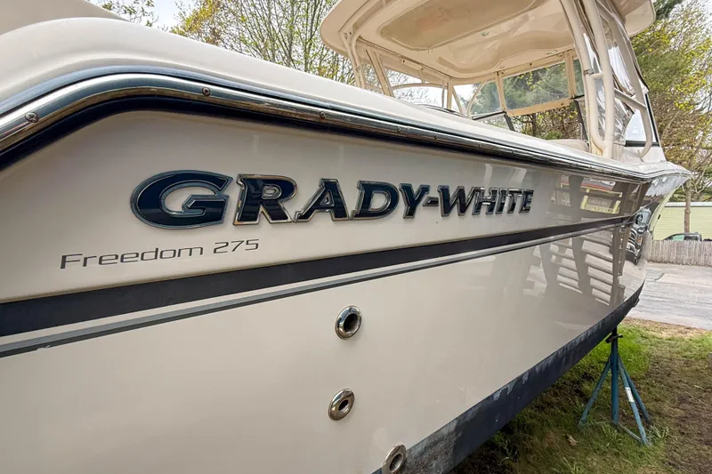 Slide: The Image of 2015 Grady-White Freedom 275 boat on display, showcasing sleek design and branding. - 49