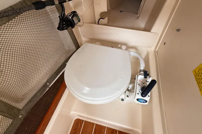 Slide: The Image of 2015 Grady-White Freedom 275 boat toilet with manual pump handle. - 24