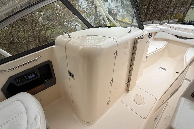 Slide: The Image of 2015 Grady-White Freedom 275 boat interior, featuring seating and control panel. - 21