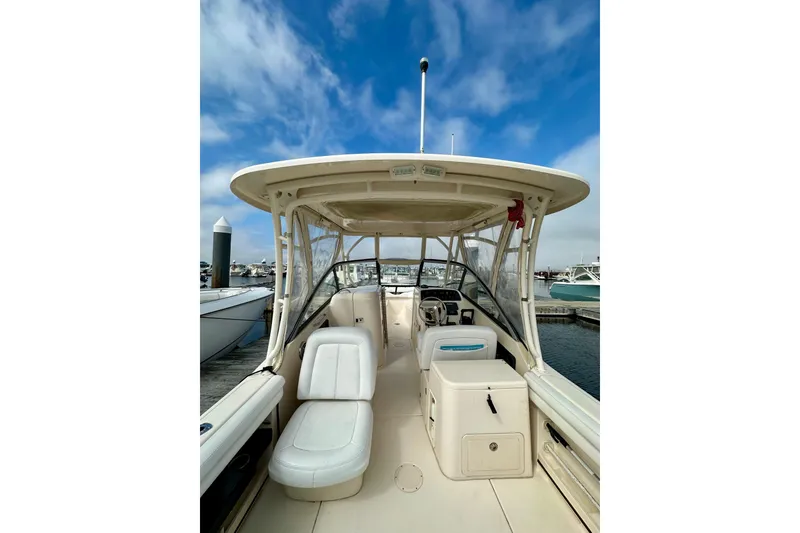 Slide: The Image of 2015 Grady-White Freedom 275 boat interior at marina, under blue sky. - 7