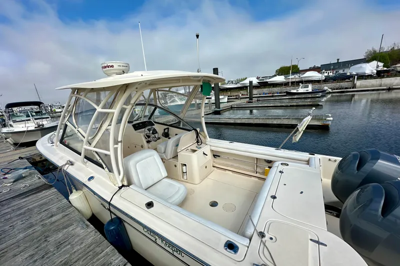 Slide: The Image of 2015 Grady-White Freedom 275 boat docked at marina, clear sky, calm water. - 4