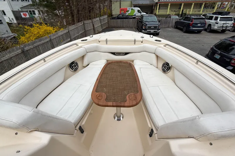 Slide: The Image of 2015 Grady-White Freedom 275 boat interior with white seating and wooden table. - 29