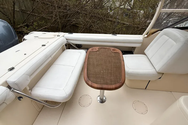Slide: The Image of 2015 Grady-White Freedom 275 boat interior with white seating and wooden table. - 37