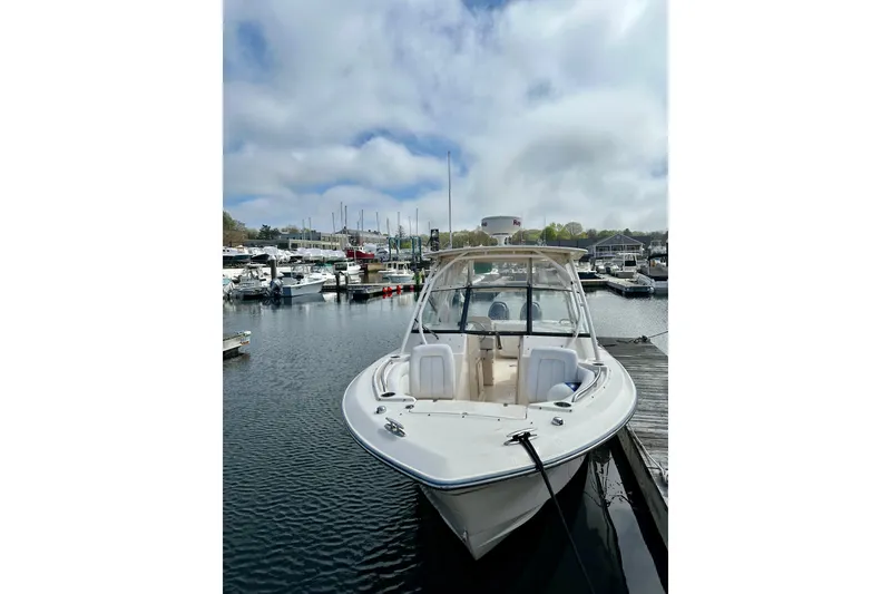 Slide: The Image of 2015 Grady-White Freedom 275 boat docked at a marina under cloudy skies. - 11