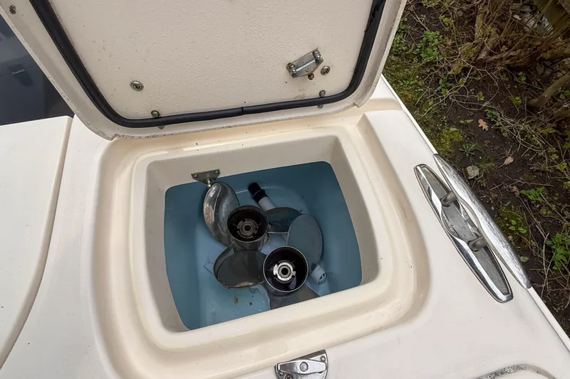 Slide: The Image of Open storage compartment on 2015 Grady-White Freedom 275 boat, containing metal propellers. - 41