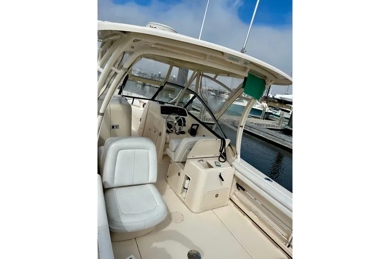 Slide: The Image of 2015 Grady-White Freedom 275 boat interior with helm and seating, docked at marina. - 6