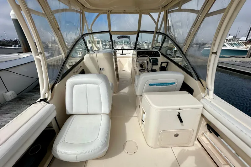Slide: The Image of 2015 Grady-White Freedom 275 boat interior with helm and seating at marina. - 8