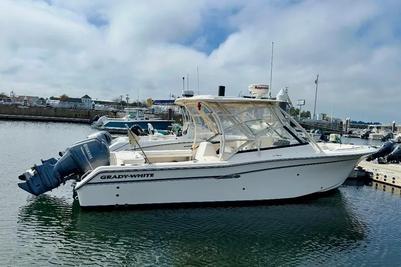 Slide: The Image of 2015 Grady-White Freedom 275 boat docked in a marina, featuring Yamaha outboard engines. - 1
