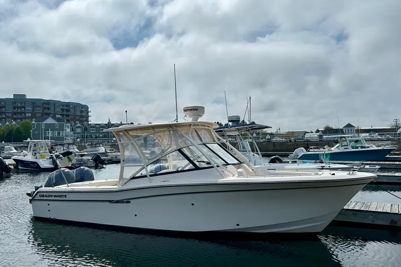 The Image of 2015 Grady-White Freedom 275 boat docked in a marina under cloudy skies. - 0