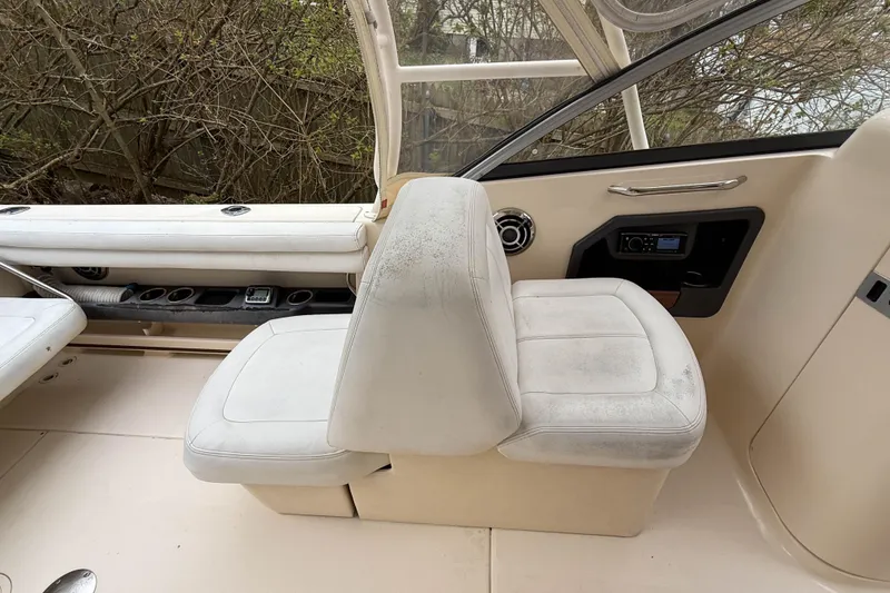 Slide: The Image of Interior of 2015 Grady-White Freedom 275 boat with white seating and control panel. - 14