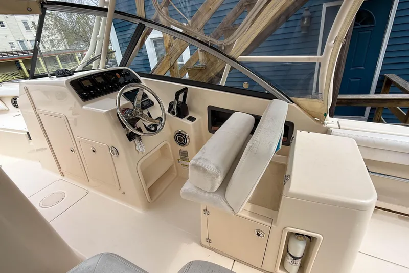 Slide: The Image of 2015 Grady-White Freedom 275 boat helm with steering wheel and control panel. - 16