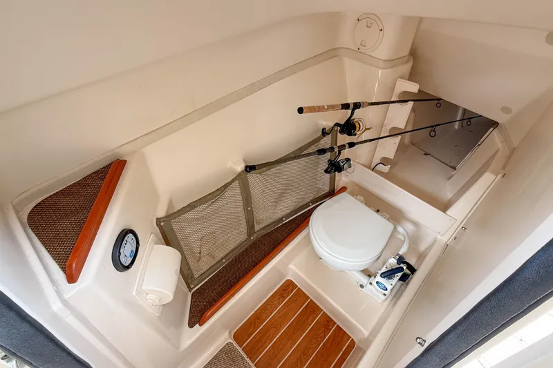 Slide: The Image of 2015 Grady-White Freedom 275 boat interior with toilet and fishing rod storage. - 23