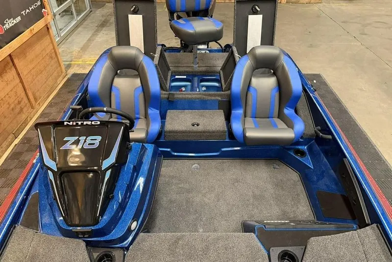 Slide: The Image of 2026 Nitro Z18 Pro boat interior with blue and gray seating, steering console, and carpeted flooring. - 7
