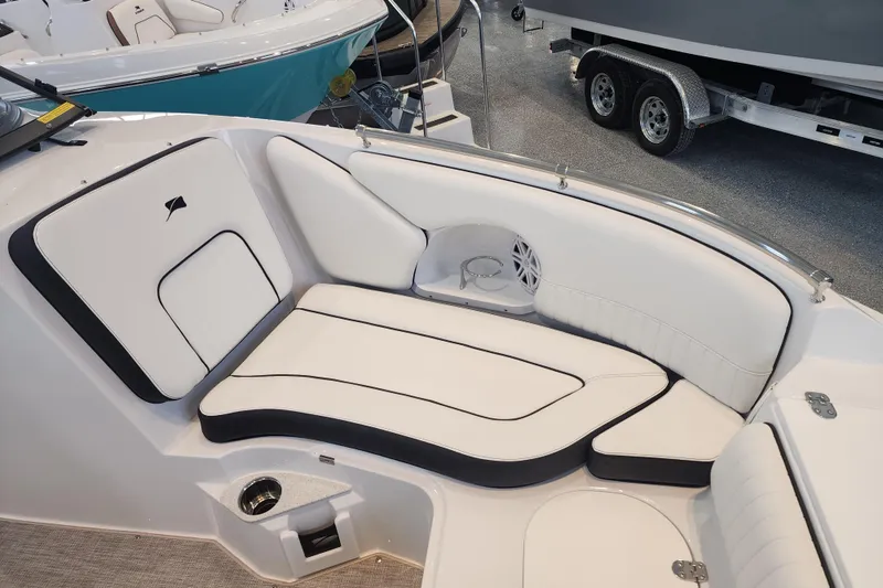 Slide: The Image of Interior seating of 2026 Stingray 211 DC boat, featuring white and black upholstery. - 10