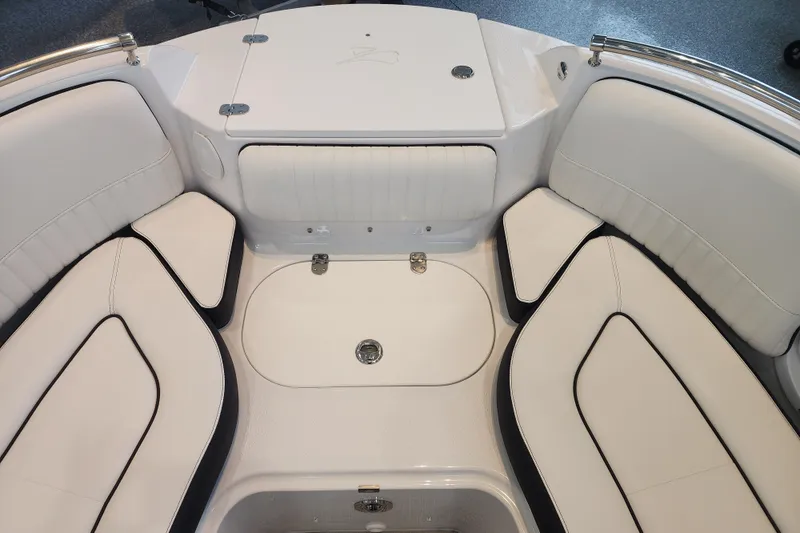 Slide: The Image of 2026 Stingray 211 DC boat interior with white cushioned seating and storage compartments. - 12