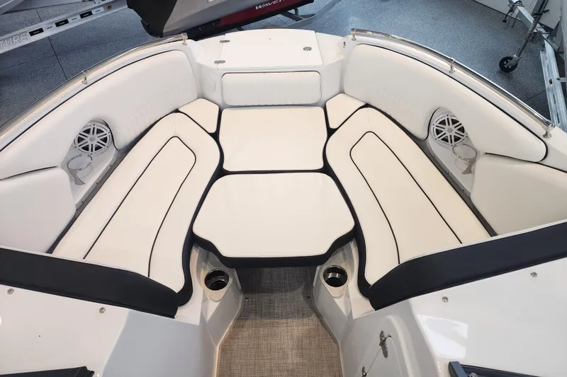 Slide: The Image of 2026 Stingray 211 DC boat interior with white cushioned seating and built-in speakers. - 16