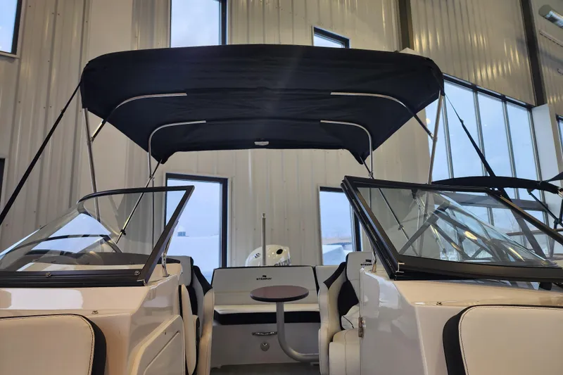 Slide: The Image of 2026 Stingray 211 DC boat interior with canopy, showcased indoors. - 24